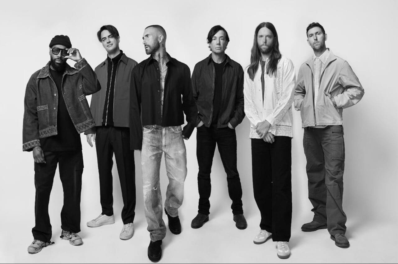 Members of American pop band Maroon 5 in a group photo against a grey background
