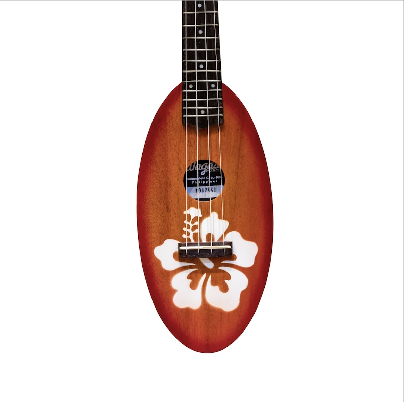 The body of a brown wooden ukulele (brand: Wagas Soprano Travel Ukulele) with a white sampaguita flower painted on its lower half, against a white backdrop