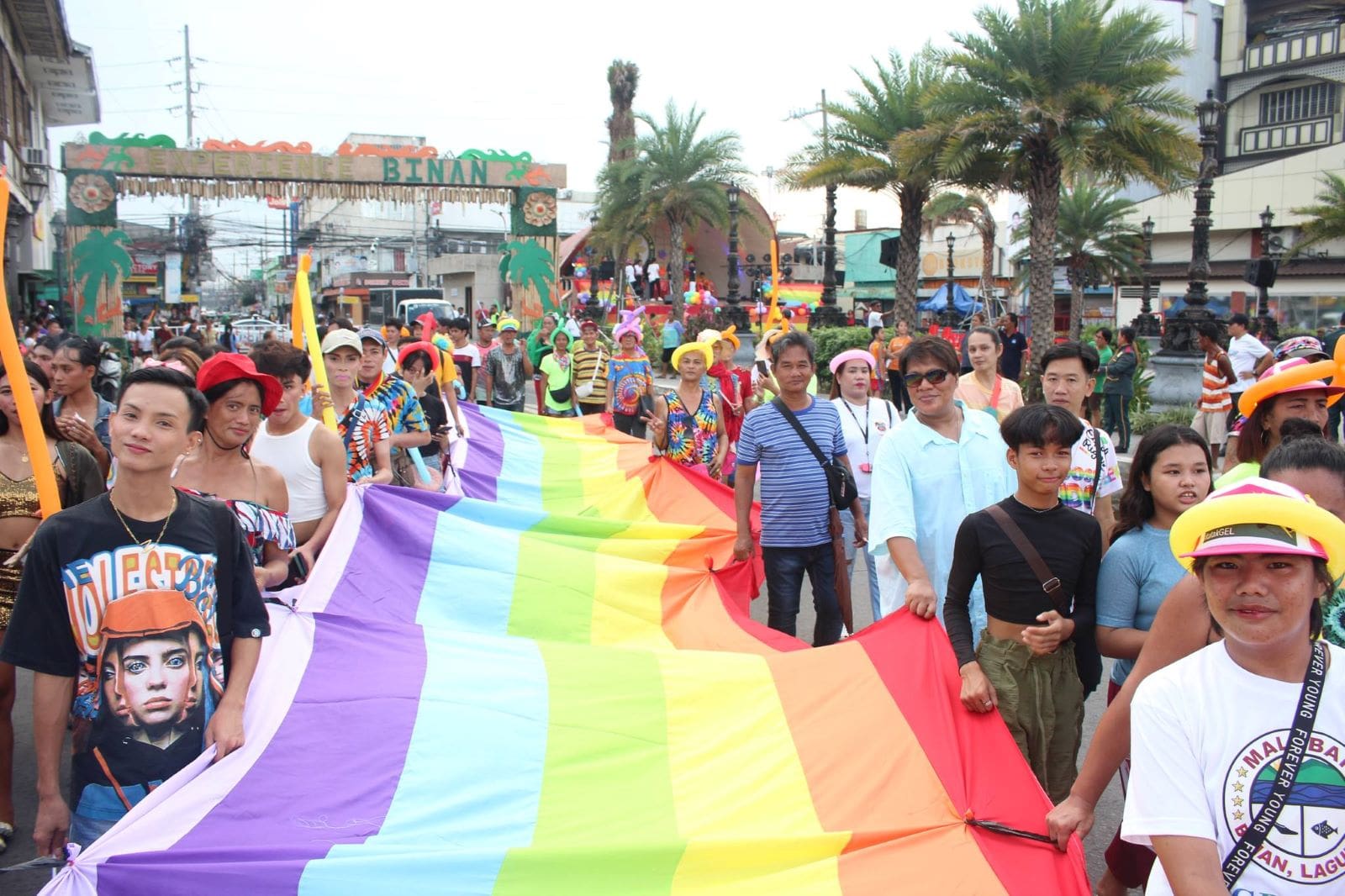Pride march goers carry a large rainbow flag in Biñan, Laguna