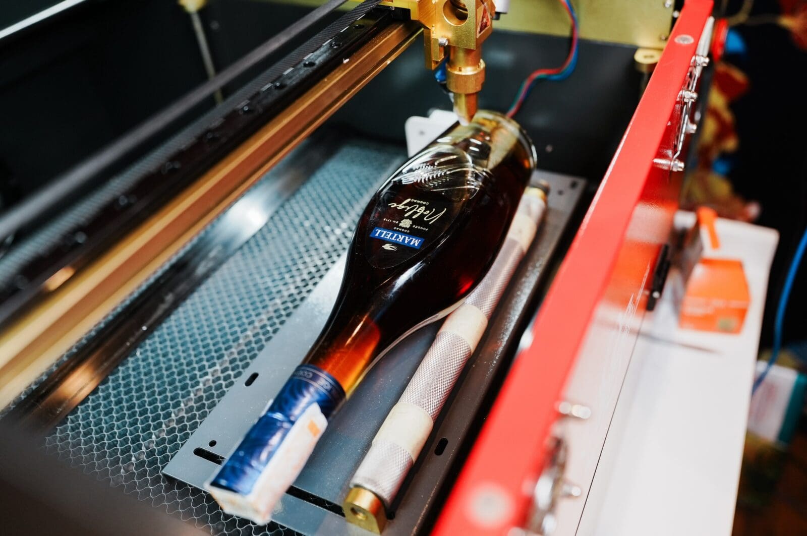 a bottle of martell cognac being engraved