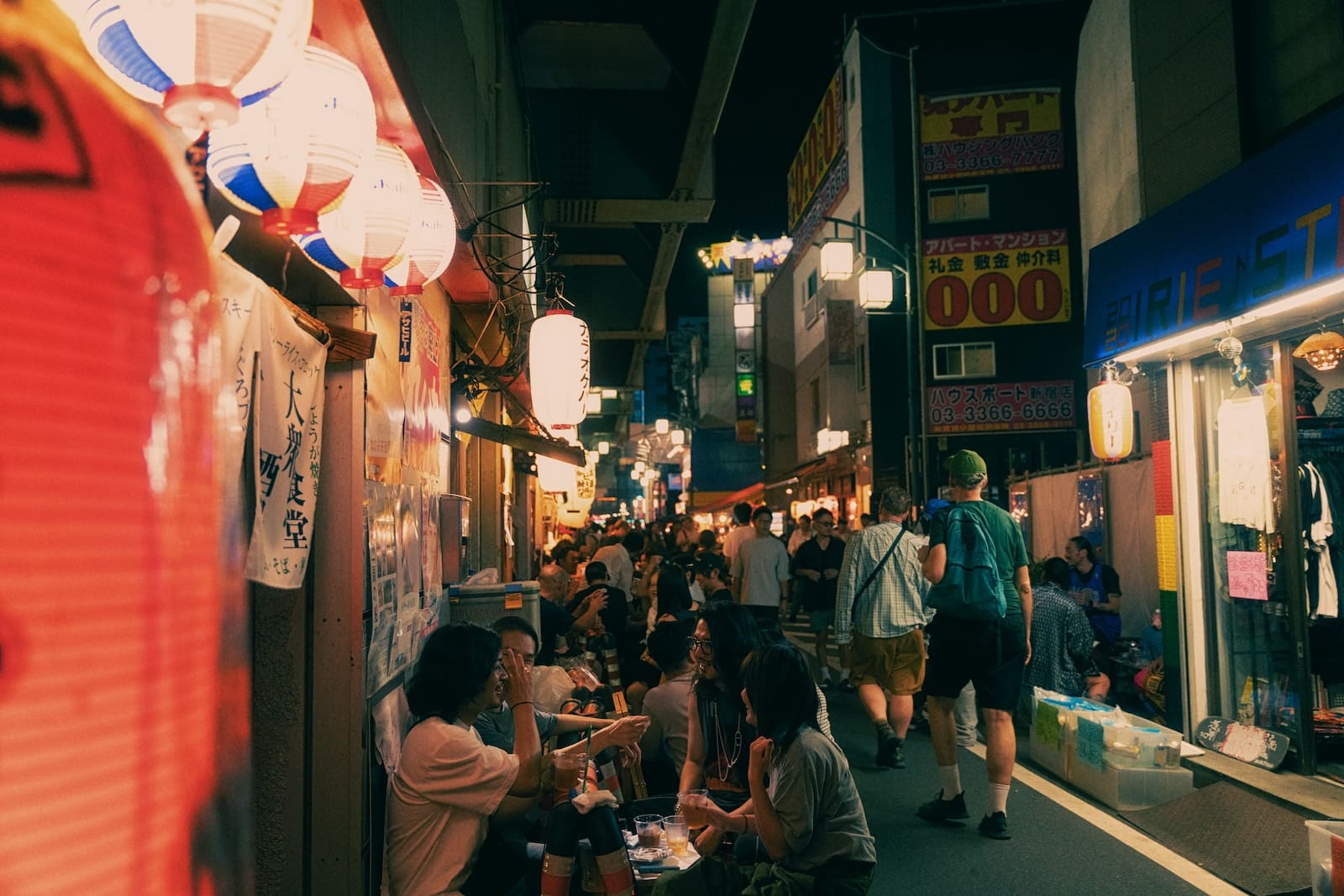 a group of people walking down a street next to stores in tokyo japan