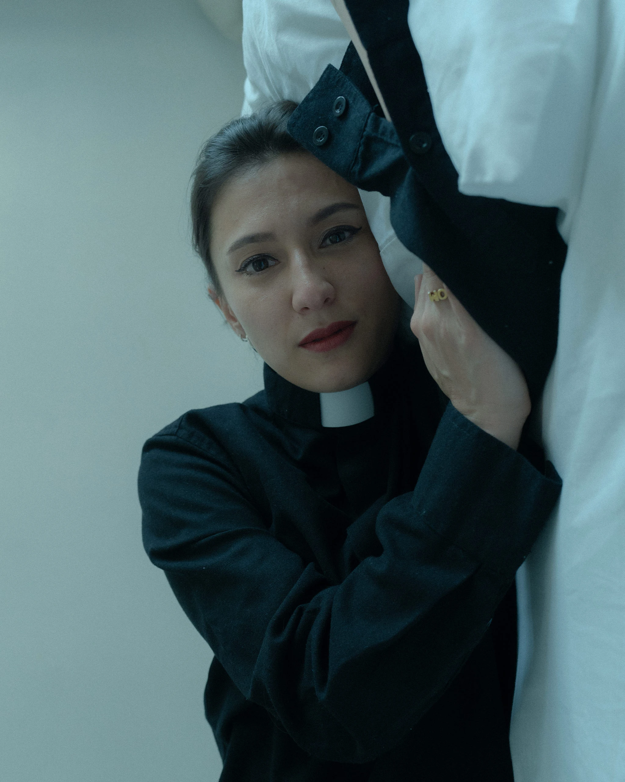 artist silke lapina dressed as a priest in bed