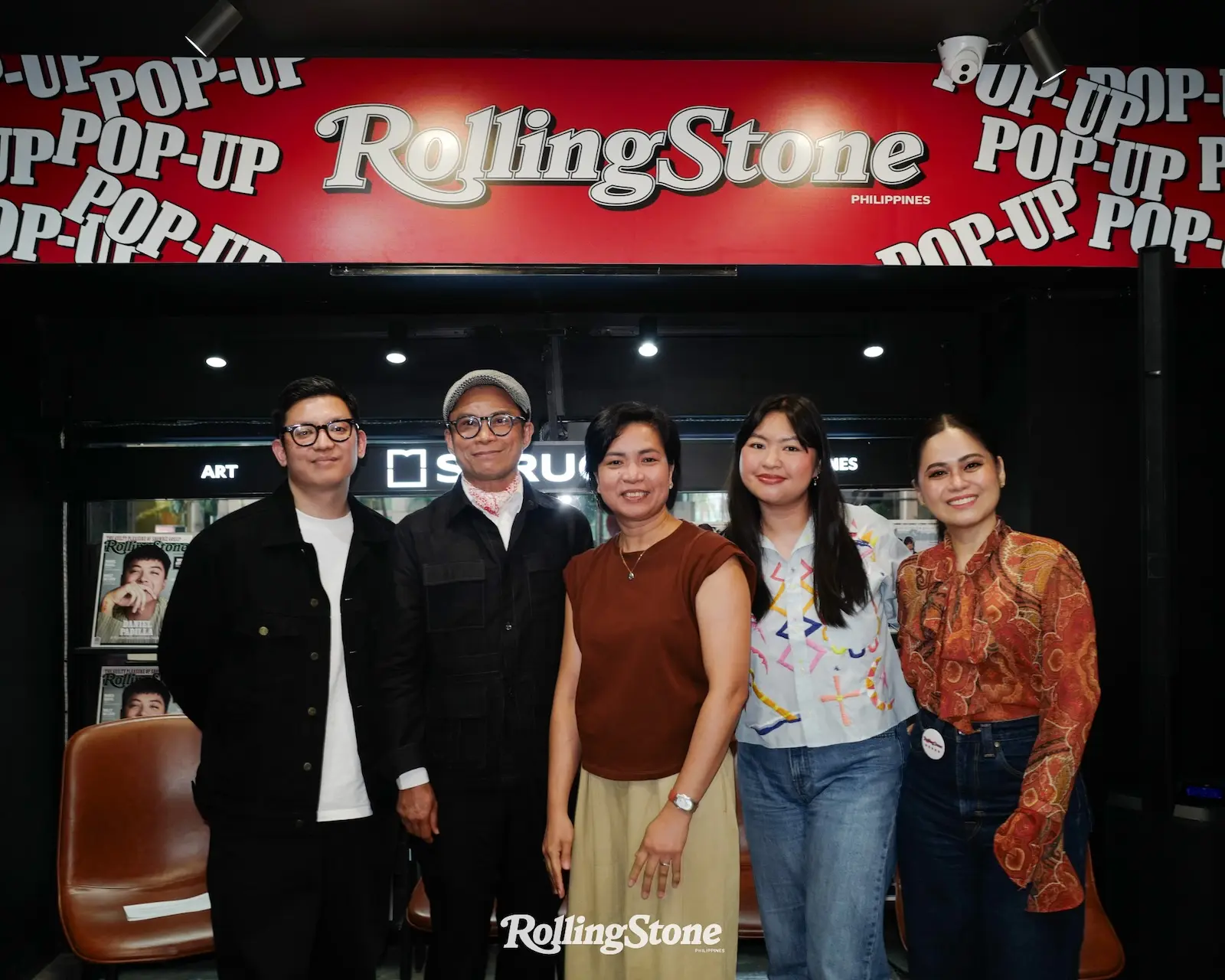Five people smiling for a group photo in front of a red Rolling Stone Philippines backdrop.